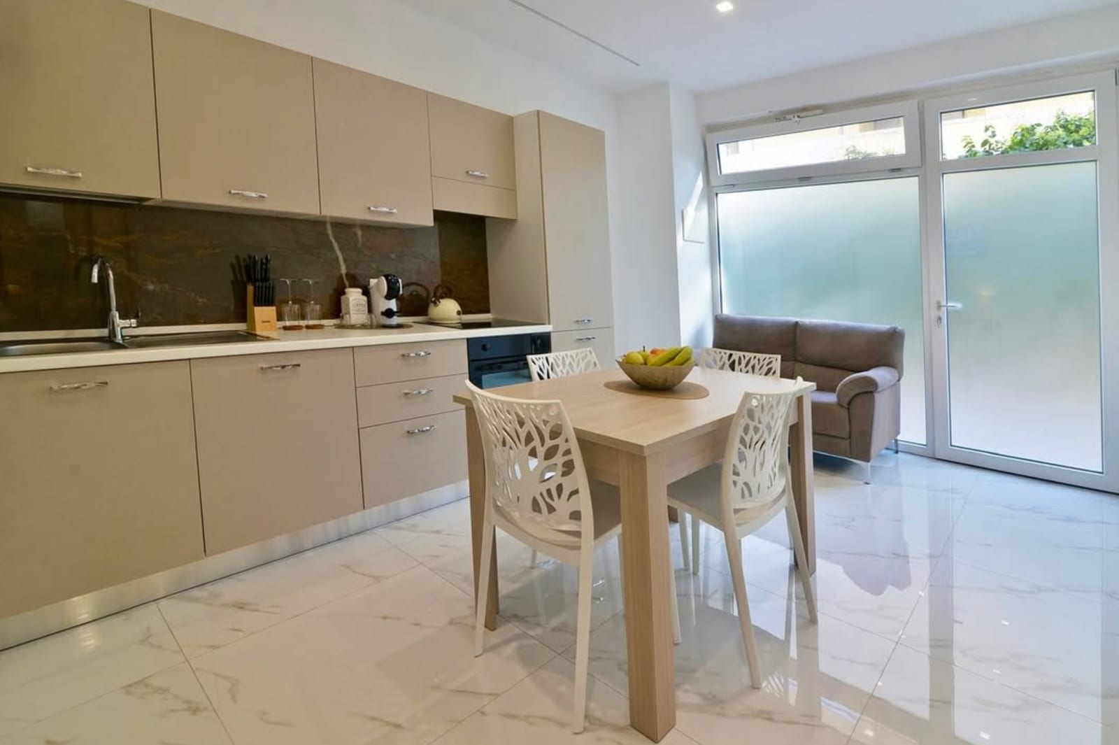 The open living space of Central Apartment Matera — kitchen, dining table and sofa
